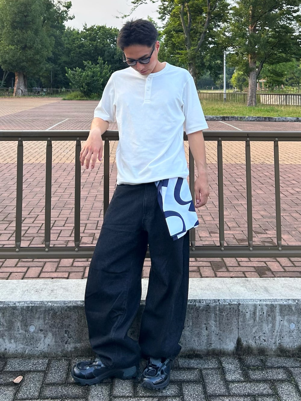 ホワイト系のTシャツ/カットソー、ブラック系のデニムパンツ、ブラック系のスニーカーを着用したメンズの夏コーディネートの2枚目の写真
