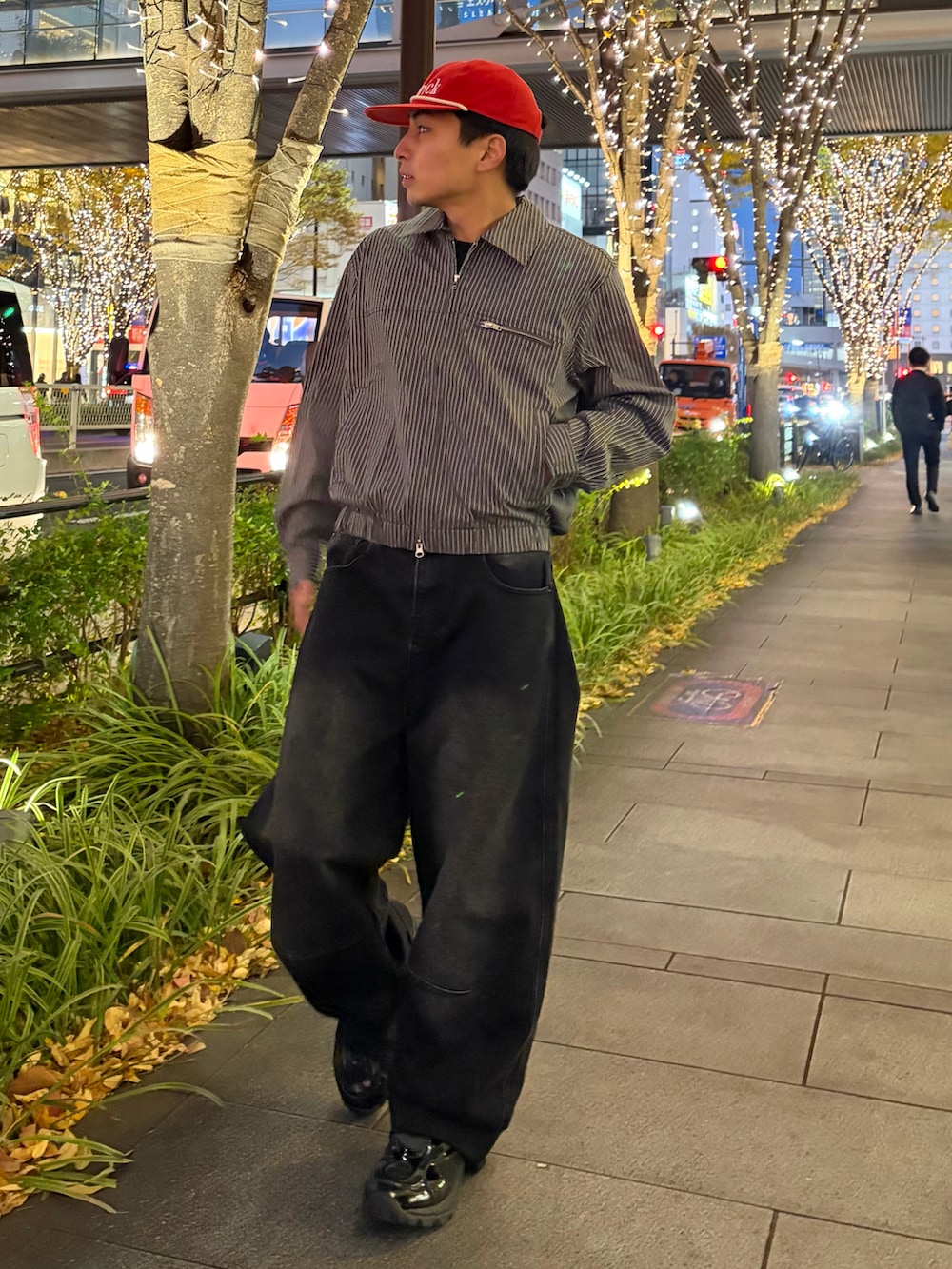 グレー系のブルゾン、ブラック系のデニムパンツ、ブラック系のスニーカーを着用したメンズの冬コーディネートの3枚目の写真