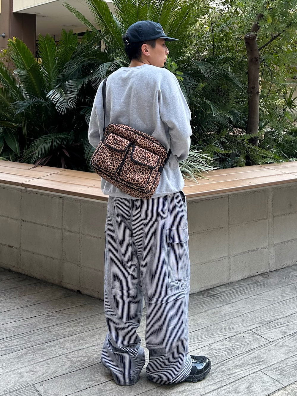 グレー系のスウェット、ブラック系のカーゴパンツ、ブラック系のスニーカーを着用したメンズの春コーディネートの3枚目の写真