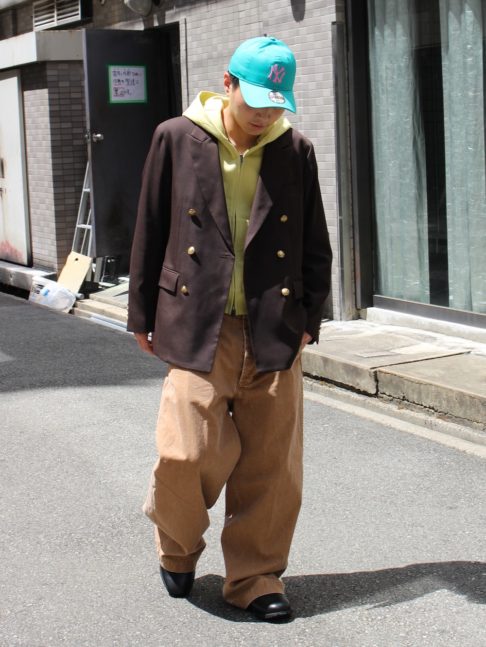 ブラウン系のパンツ、ブラウン系のローファー、グリーン系のパーカーを着用したメンズの秋コーディネートの2枚目の写真