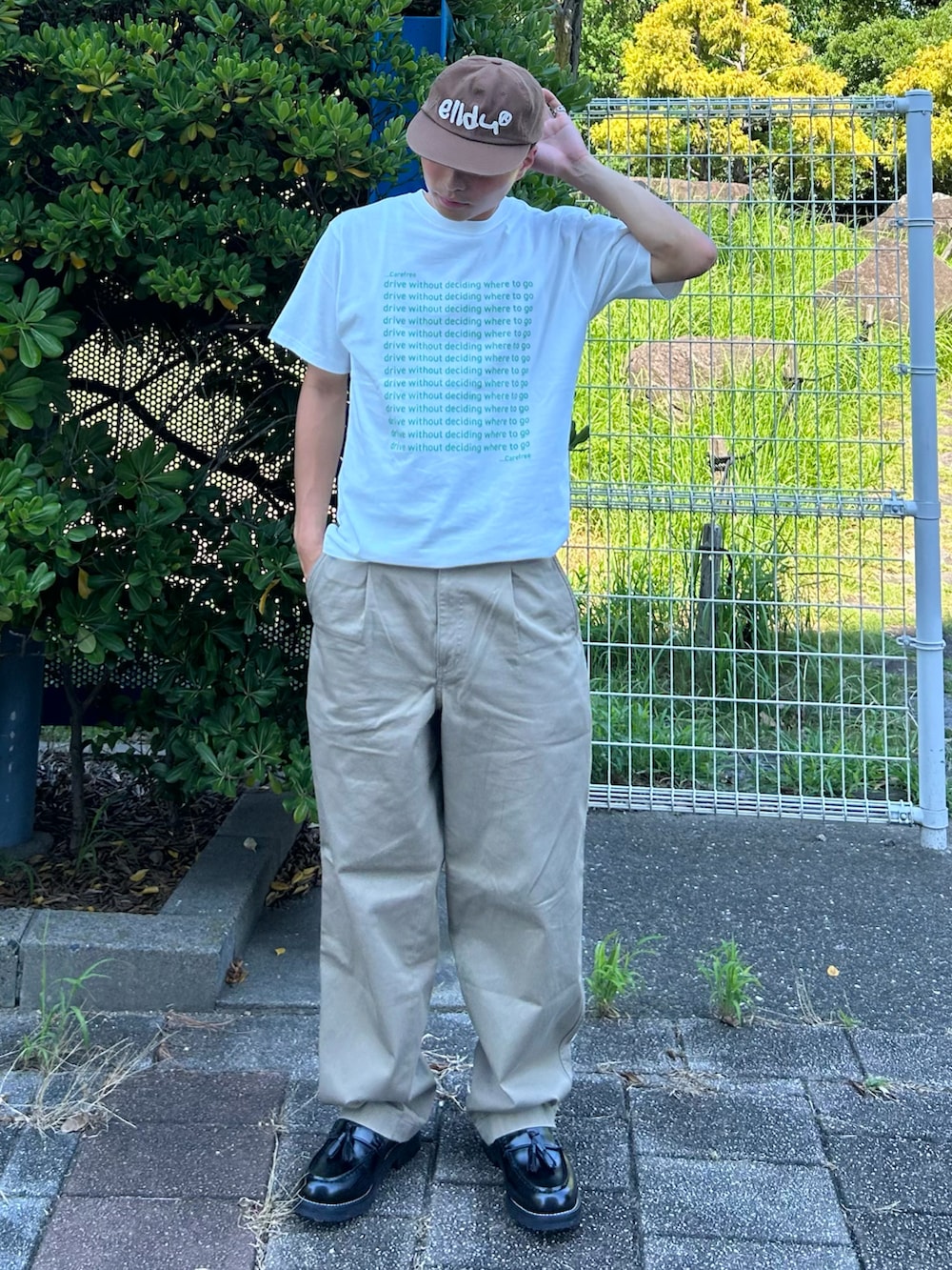 グリーン系のTシャツ/カットソー、ブラック系のローファー、ベージュ系のデニムパンツを着用したメンズの秋コーディネートの2枚目の写真