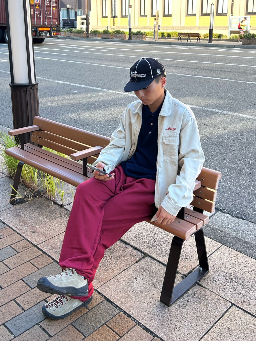 ブルー系のニット/セーター、ベージュ系のジャケット/アウター、レッド系のスウェットパンツを着用したメンズの秋コーディネートの2枚目の写真
