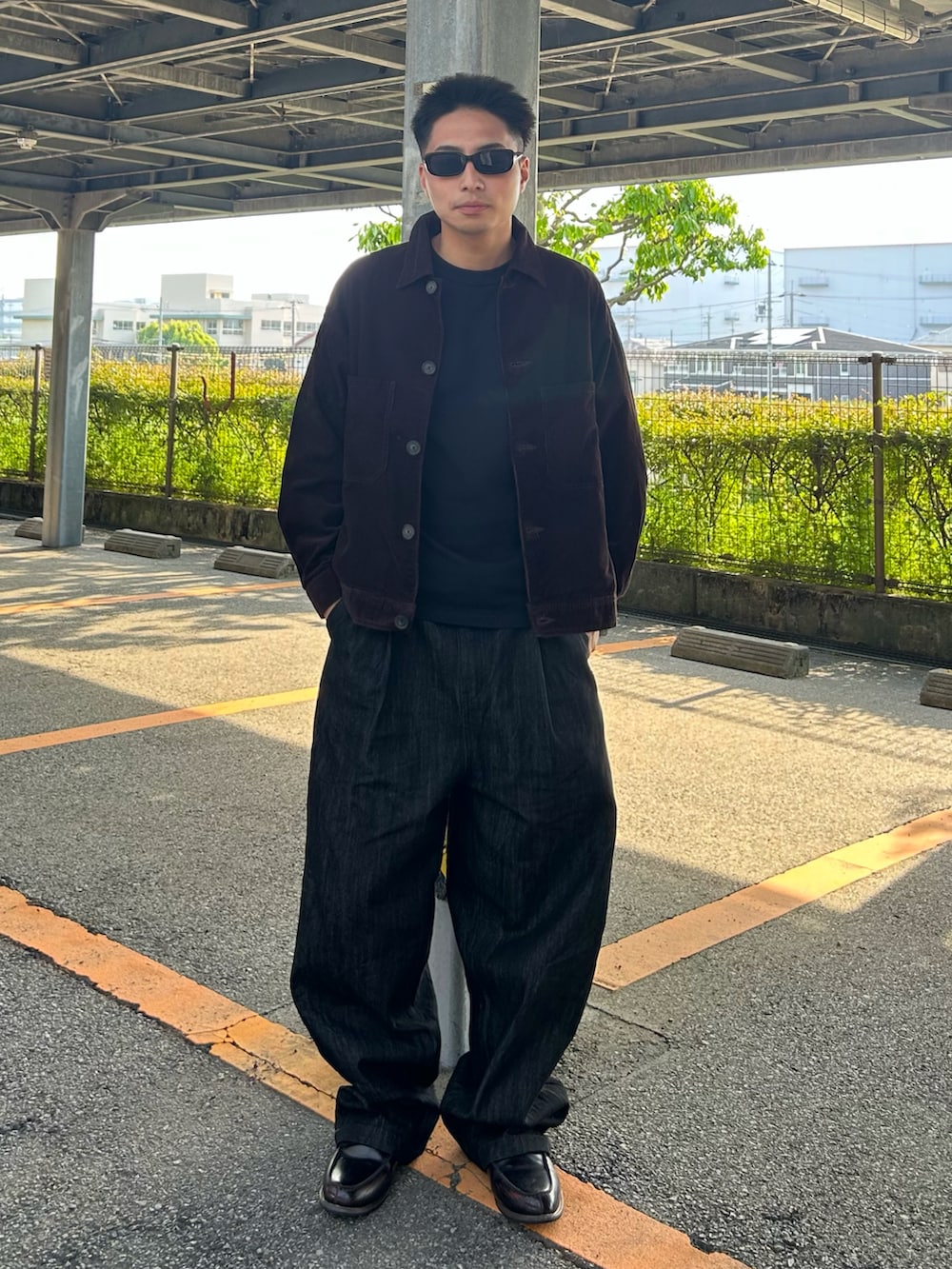 ブラック系のデニムパンツ、ブラウン系のローファー、ブラウン系のジャケット/アウターを着用したメンズの春コーディネートの2枚目の写真