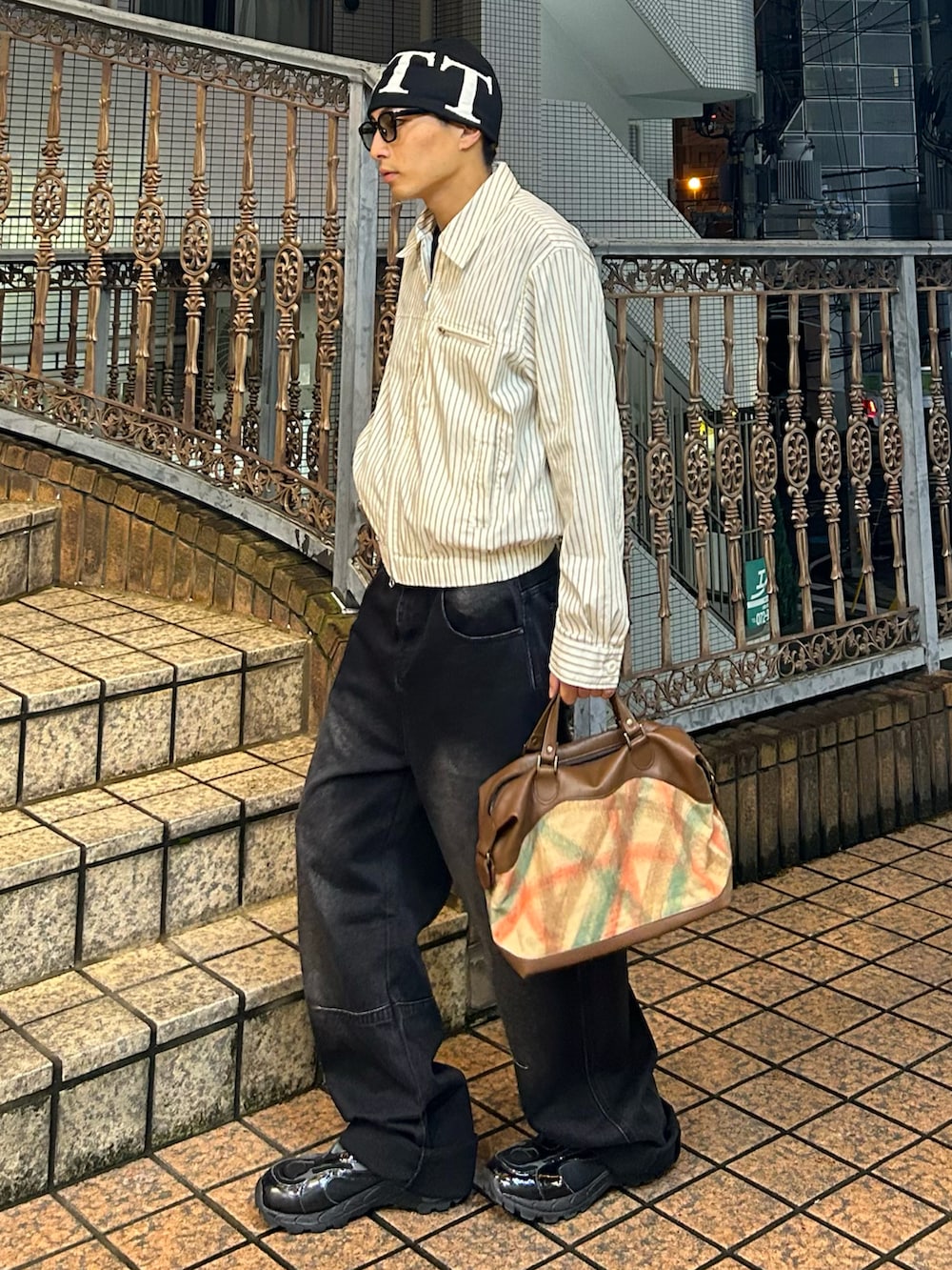 ベージュ系のブルゾン、ブラック系のデニムパンツ、その他のバッグを着用したメンズの秋コーディネートの2枚目の写真