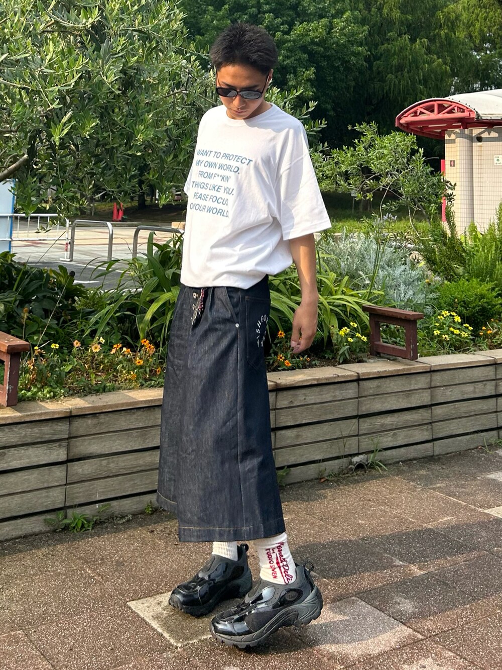 ブルー系のデニムパンツ、ホワイト系のTシャツ/カットソー、ブラック系のスニーカーを着用したメンズの夏コーディネートの2枚目の写真