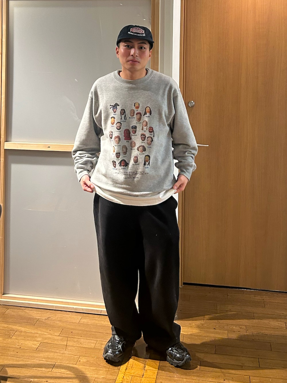 グレー系のスウェット、ブラック系のスウェットパンツ、ブラック系のスニーカーを着用したメンズの冬コーディネートの2枚目の写真