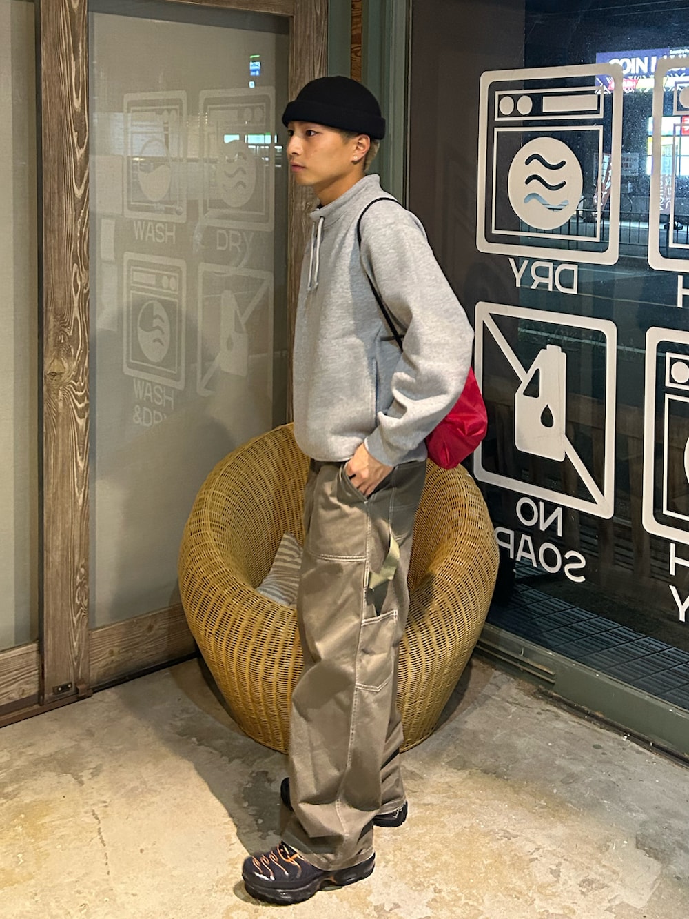 グレー系のスウェット、グリーン系のパンツ、ブラック系のスニーカーを着用したメンズの秋コーディネートの2枚目の写真