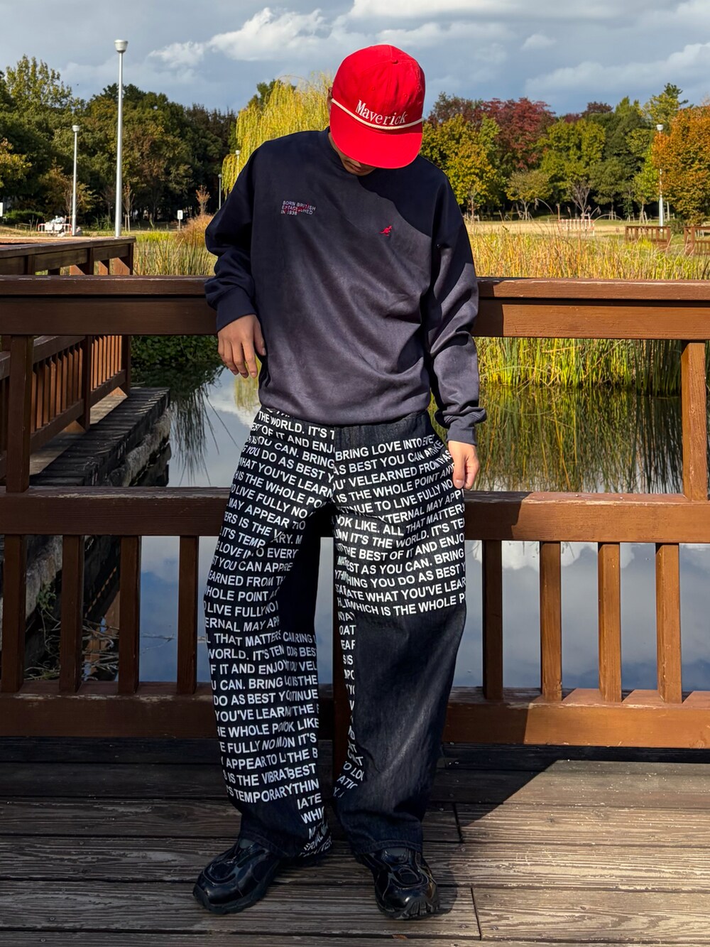 ブルー系のスウェット、ブルー系のデニムパンツ、ブラック系のスニーカーを着用したメンズの冬コーディネートの3枚目の写真