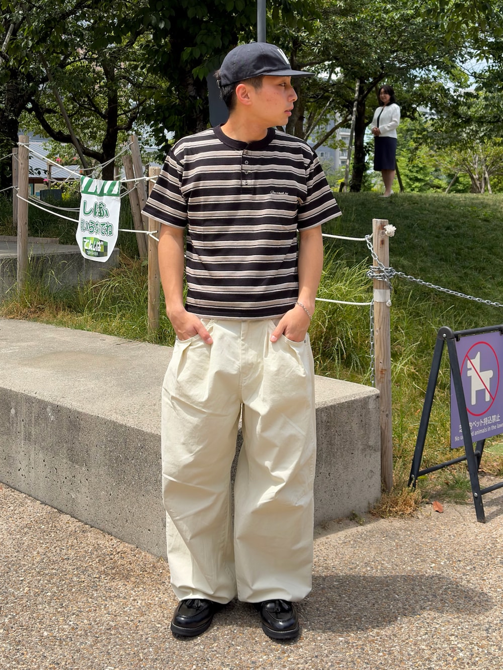 ブラック系のTシャツ/カットソー、ホワイト系のスラックス、ブラック系のローファーを着用したメンズの夏コーディネートの2枚目の写真