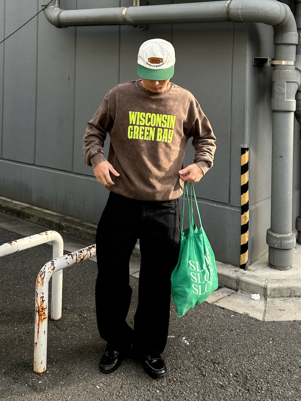 ブラウン系のスウェット、ブラック系のデニムパンツ、ブラック系のローファーを着用したメンズの冬コーディネートの2枚目の写真