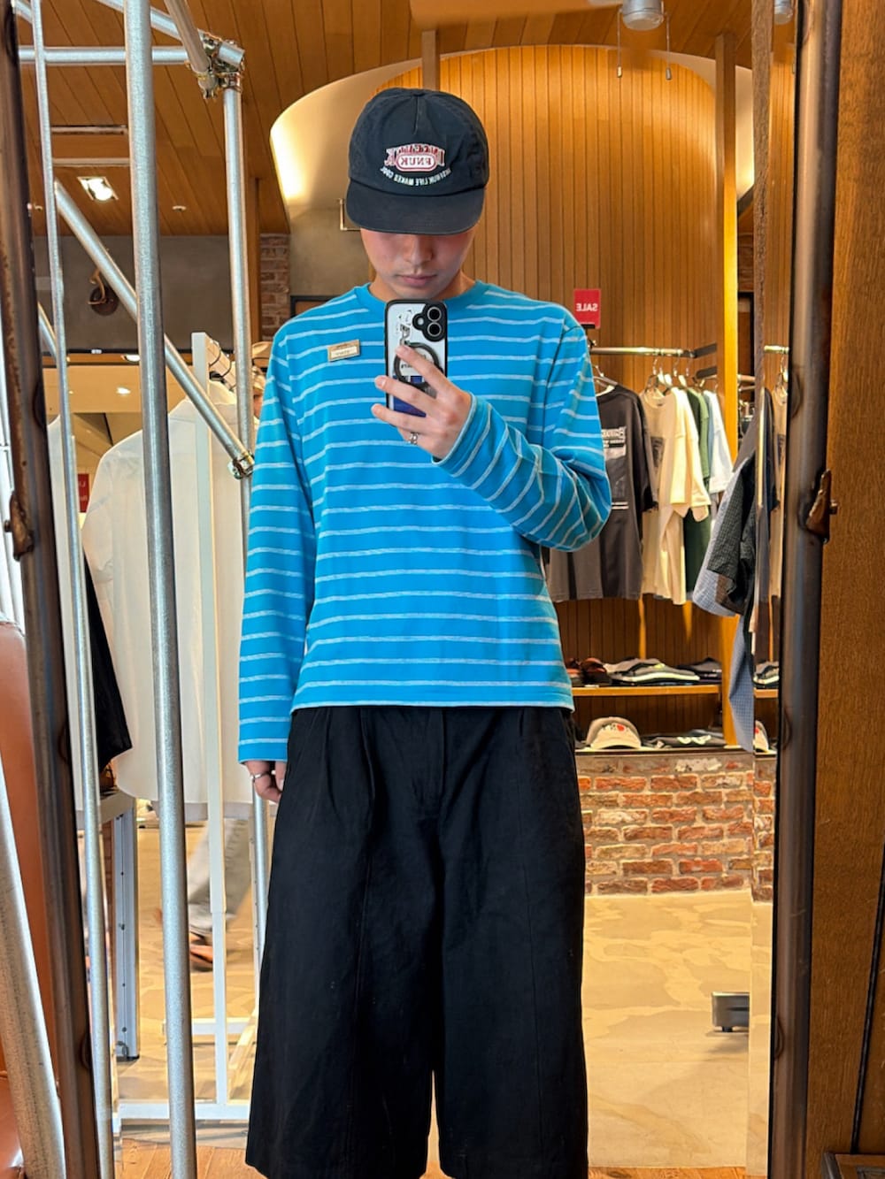ブルー系のTシャツ/カットソー、ブラック系のパンツ、ブラック系のローファーを着用したメンズの夏コーディネートの2枚目の写真