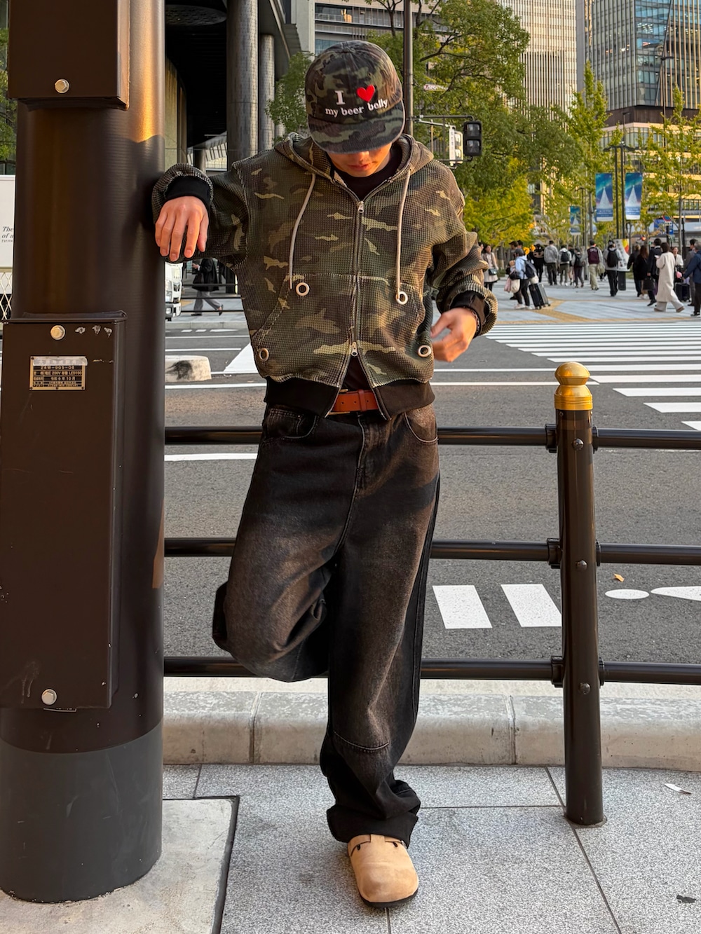 ベージュ系のサンダル、グリーン系のパーカー、ブラック系のデニムパンツを着用したメンズの冬コーディネートの2枚目の写真