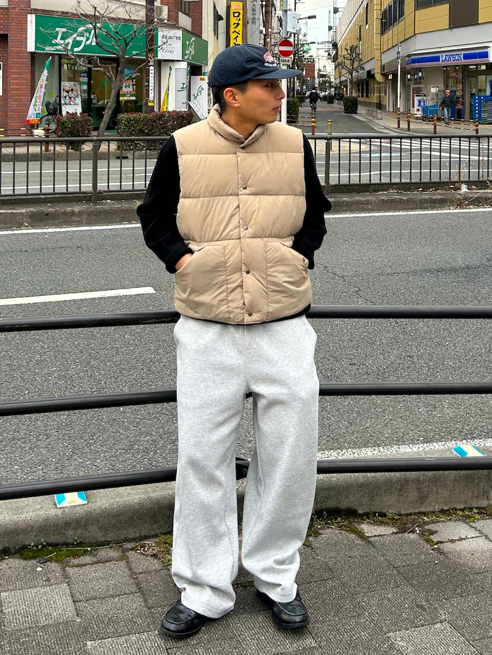 ベージュ系のダウンベスト、グレー系のスウェットパンツ、ブラック系のローファーを着用したメンズの冬コーディネートの2枚目の写真