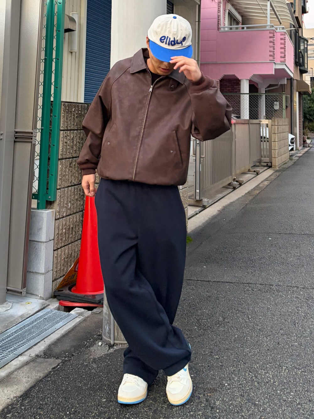ブラウン系のブルゾン、ホワイト系のスニーカー、ブルー系のスウェットパンツを着用したメンズの冬コーディネートの2枚目の写真