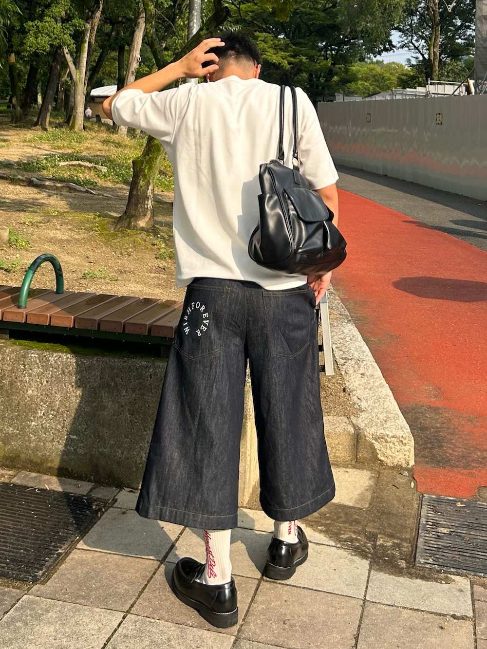 ブルー系のデニムパンツ、ブラック系のローファー、ホワイト系のTシャツ/カットソーを着用したメンズの夏コーディネートの2枚目の写真