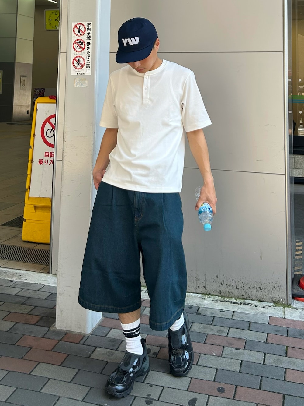 ホワイト系のTシャツ/カットソー、ブルー系のデニムパンツ、ブラック系のスニーカーを着用したメンズの夏コーディネートの2枚目の写真