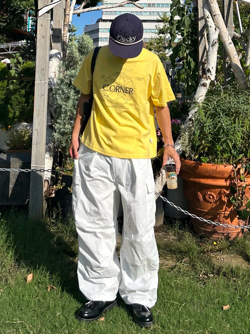 イエロー系のTシャツ/カットソー、ブラック系のボストンバッグ、ブラック系のローファーを着用したメンズの秋コーディネートの3枚目の写真