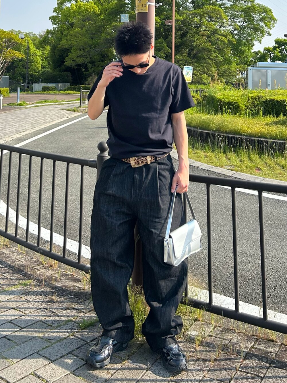 ブラック系のTシャツ/カットソー、ブラック系のデニムパンツ、シルバー系のショルダーバッグを着用したメンズの春コーディネートの2枚目の写真