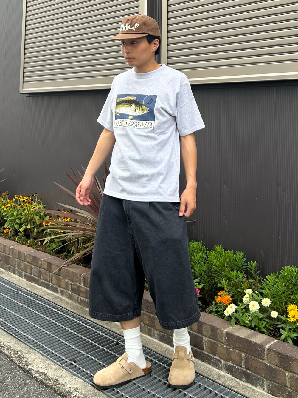 ベージュ系のサンダル、グレー系のTシャツ/カットソー、ブラック系のデニムパンツを着用したメンズの夏コーディネートの2枚目の写真