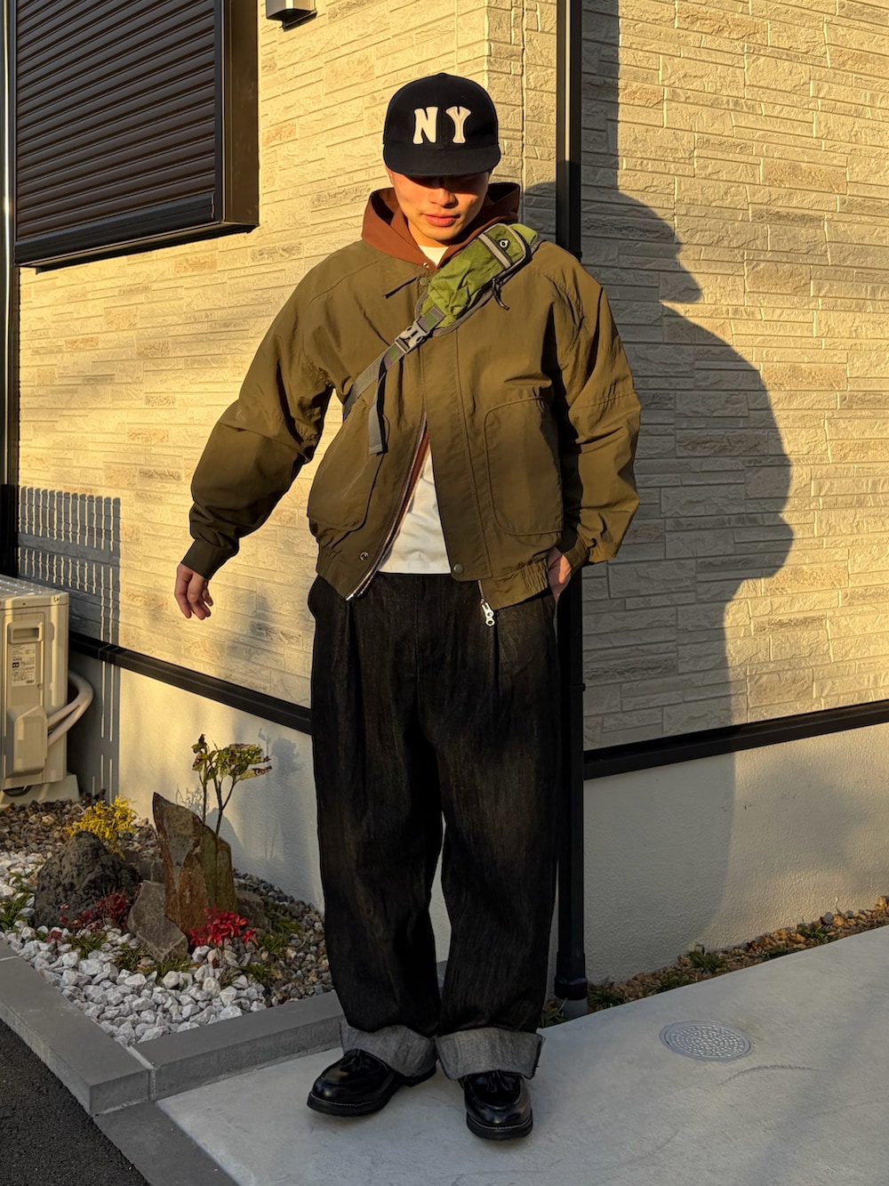 グリーン系のショルダーバッグ、ブラック系のローファー、グリーン系のテーラードジャケットを着用したメンズの冬コーディネートの2枚目の写真