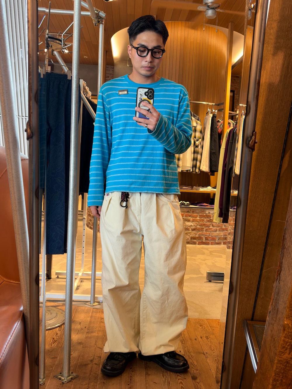 ブルー系のTシャツ/カットソー、ホワイト系のスラックス、ブラック系のローファーを着用したメンズの夏コーディネートの2枚目の写真