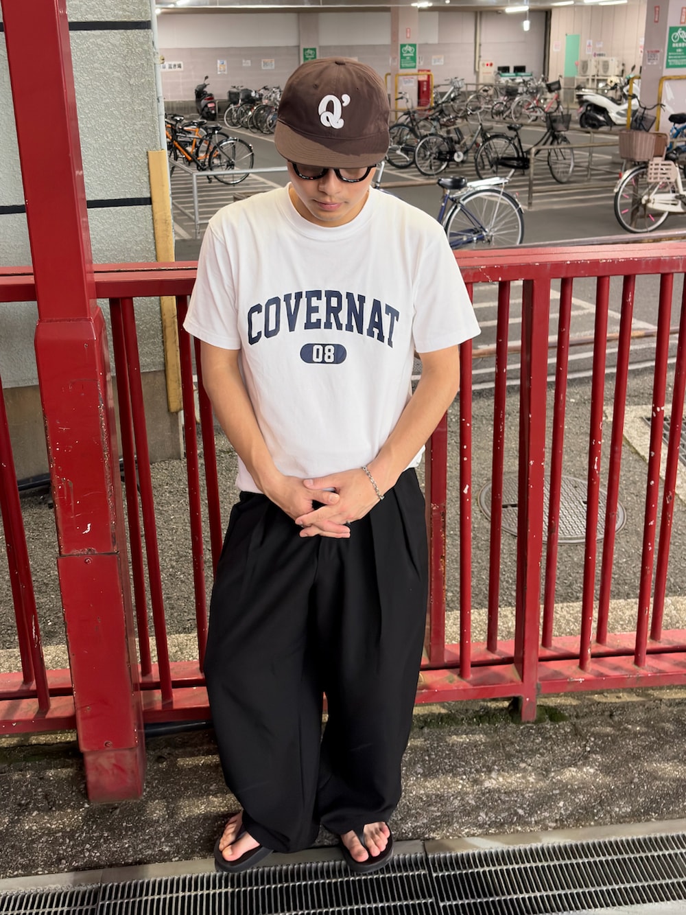 ホワイト系のTシャツ/カットソー、ブラック系のスラックス、ブラウン系のキャップを着用したメンズの春コーディネートの3枚目の写真