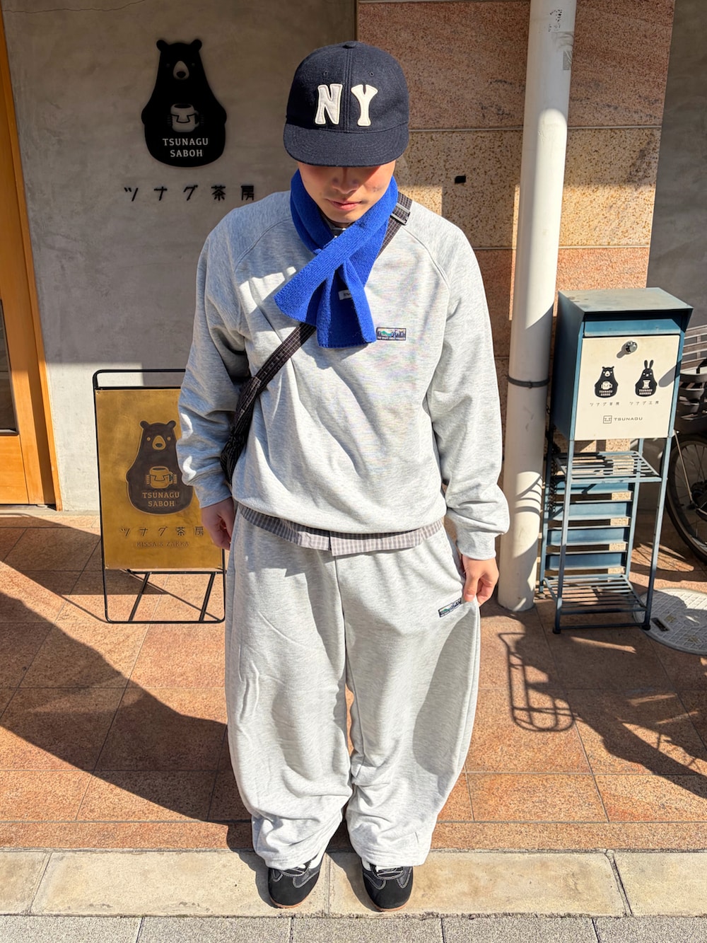 グレー系のスウェットパンツ、グレー系のスウェット、ブラック系のスニーカーを着用したメンズの春コーディネートの2枚目の写真