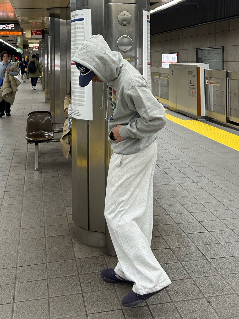 グレー系のスウェット、グレー系のスウェットパンツ、パープル系のスニーカーを着用したメンズの冬コーディネートの2枚目の写真