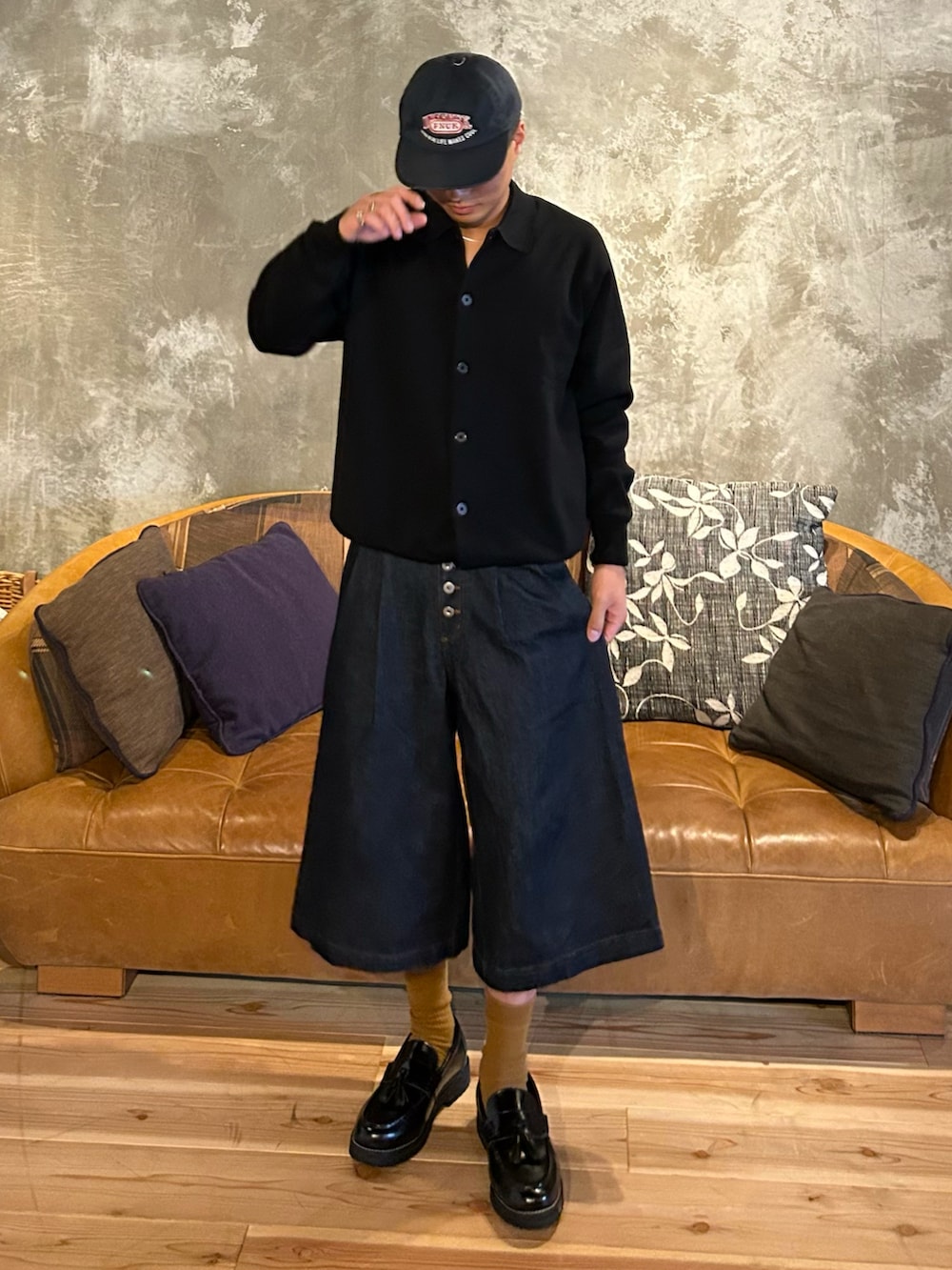 ブルー系のデニムパンツ、ブラック系のローファー、ブラック系のニット/セーターを着用したメンズの秋コーディネートの2枚目の写真