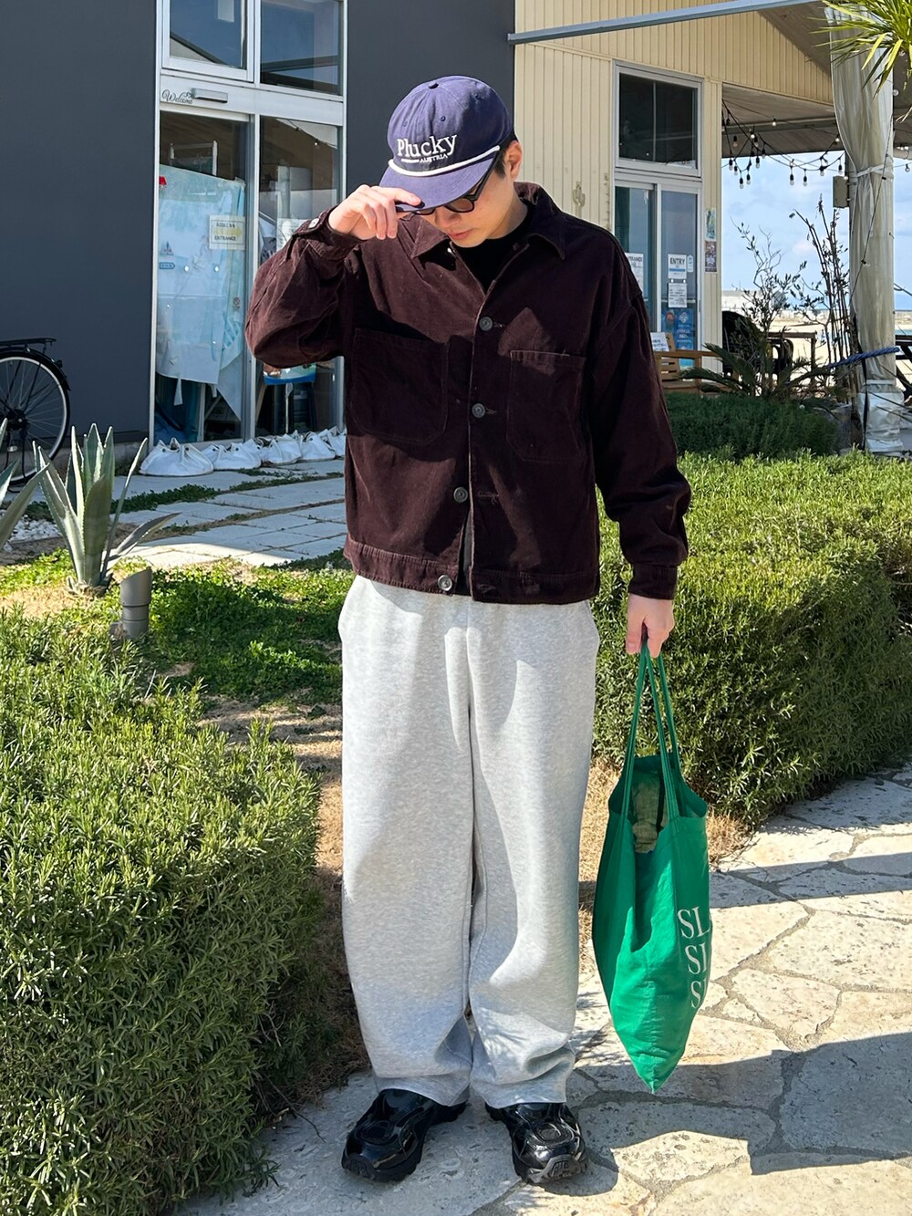 ブラウン系のジャケット/アウター、グレー系のスウェットパンツ、グリーン系のトートバッグを着用したメンズの冬コーディネートの2枚目の写真
