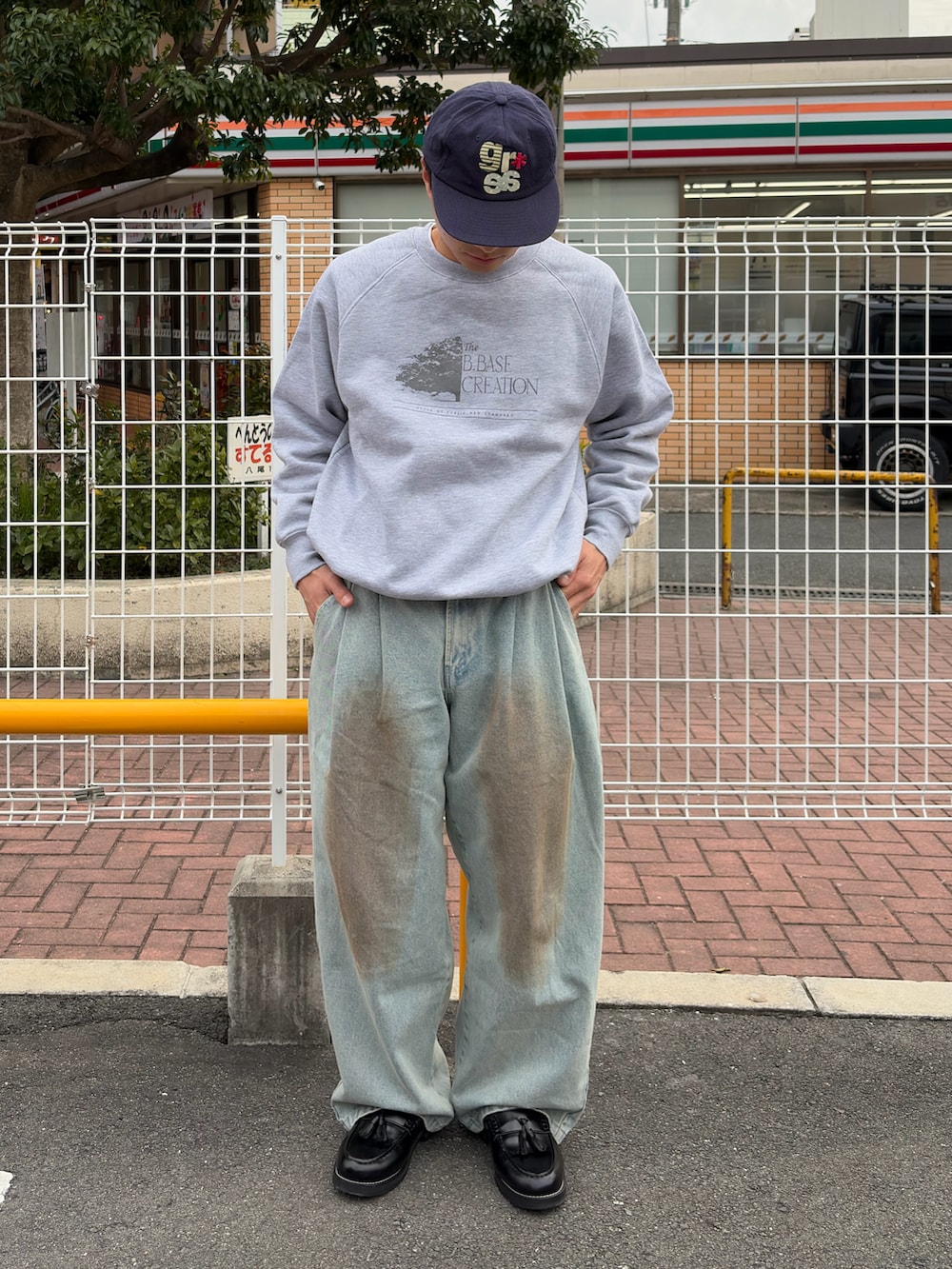 ブルー系のデニムパンツ、グレー系のスウェット、ブラック系のローファーを着用したメンズの春コーディネートの2枚目の写真