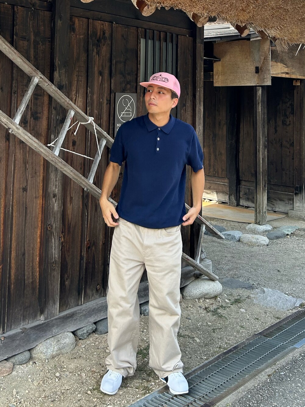 ブルー系のニット/セーター、ベージュ系のデニムパンツ、ホワイト系のスニーカーを着用したメンズの秋コーディネートの2枚目の写真
