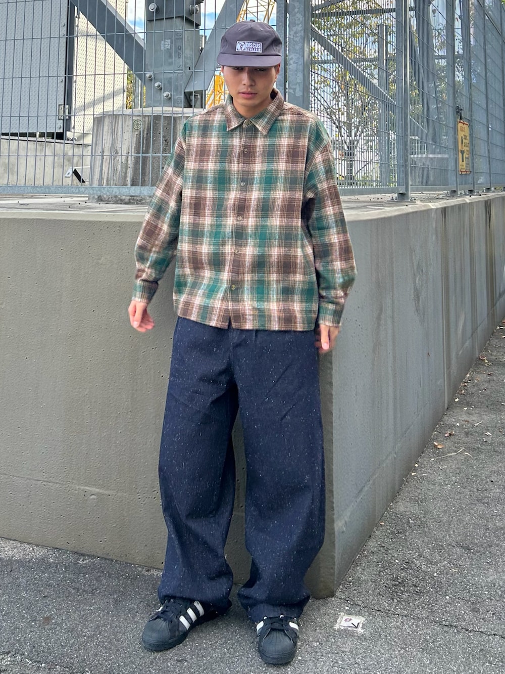 ブルー系のデニムパンツ、グリーン系のシャツ/ブラウス、ブラック系のスニーカーを着用したメンズの冬コーディネートの2枚目の写真