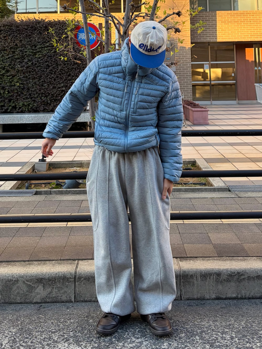 ブラウン系のスニーカー、ブルー系のジャケット/アウター、グレー系のスウェットパンツを着用したメンズの冬コーディネートの2枚目の写真