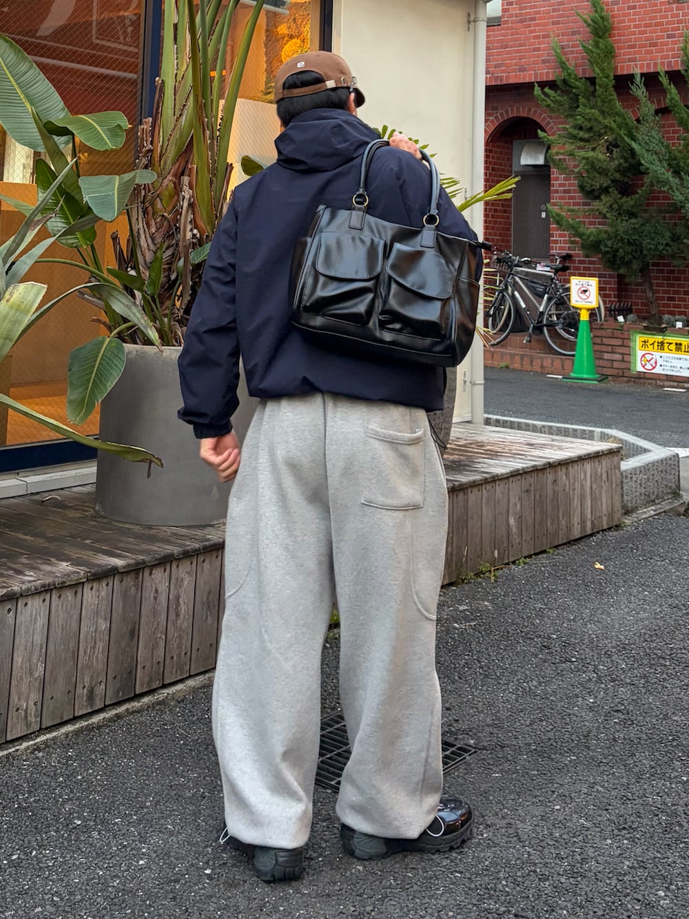 ブルー系のナイロンジャケット、グレー系のスウェットパンツ、ブラック系のスニーカーを着用したメンズの冬コーディネートの2枚目の写真