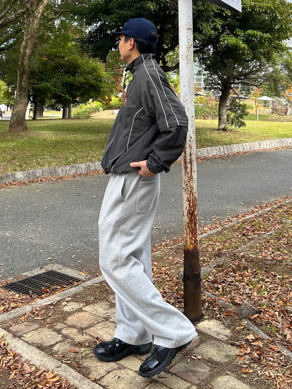 グレー系のナイロンジャケット、グレー系のスウェットパンツ、ブラック系のスニーカーを着用したメンズの冬コーディネートの2枚目の写真