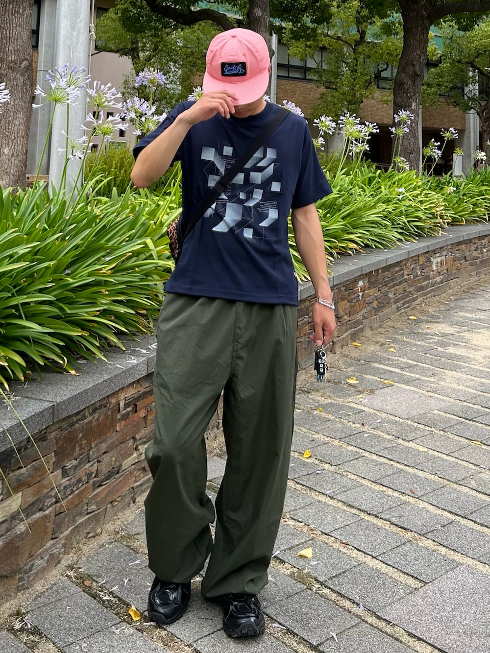 ブルー系のTシャツ/カットソー、グリーン系のカーゴパンツ、ブラック系のスニーカーを着用したメンズの夏コーディネートの2枚目の写真
