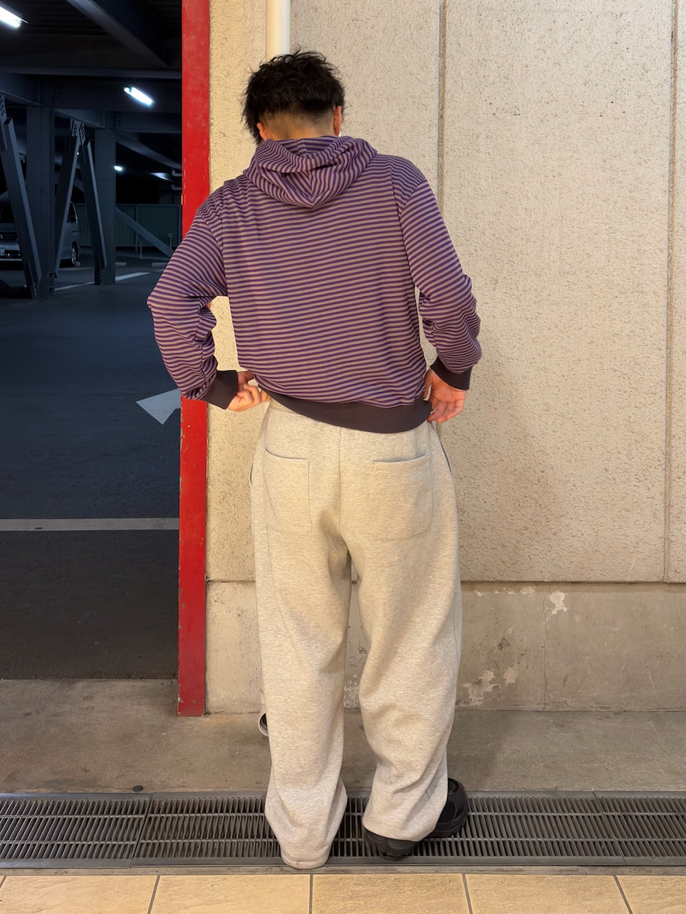 パープル系のパーカー、グレー系のスウェットパンツ、ブラック系のスニーカーを着用したメンズの春コーディネートの2枚目の写真