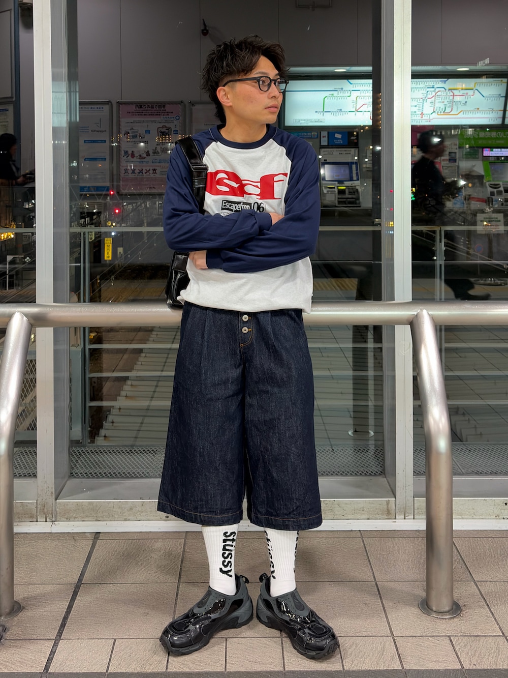 ブルー系のデニムパンツ、その他のメッセンジャーバッグ、ホワイト系のTシャツ/カットソーを着用したメンズの春コーディネートの2枚目の写真