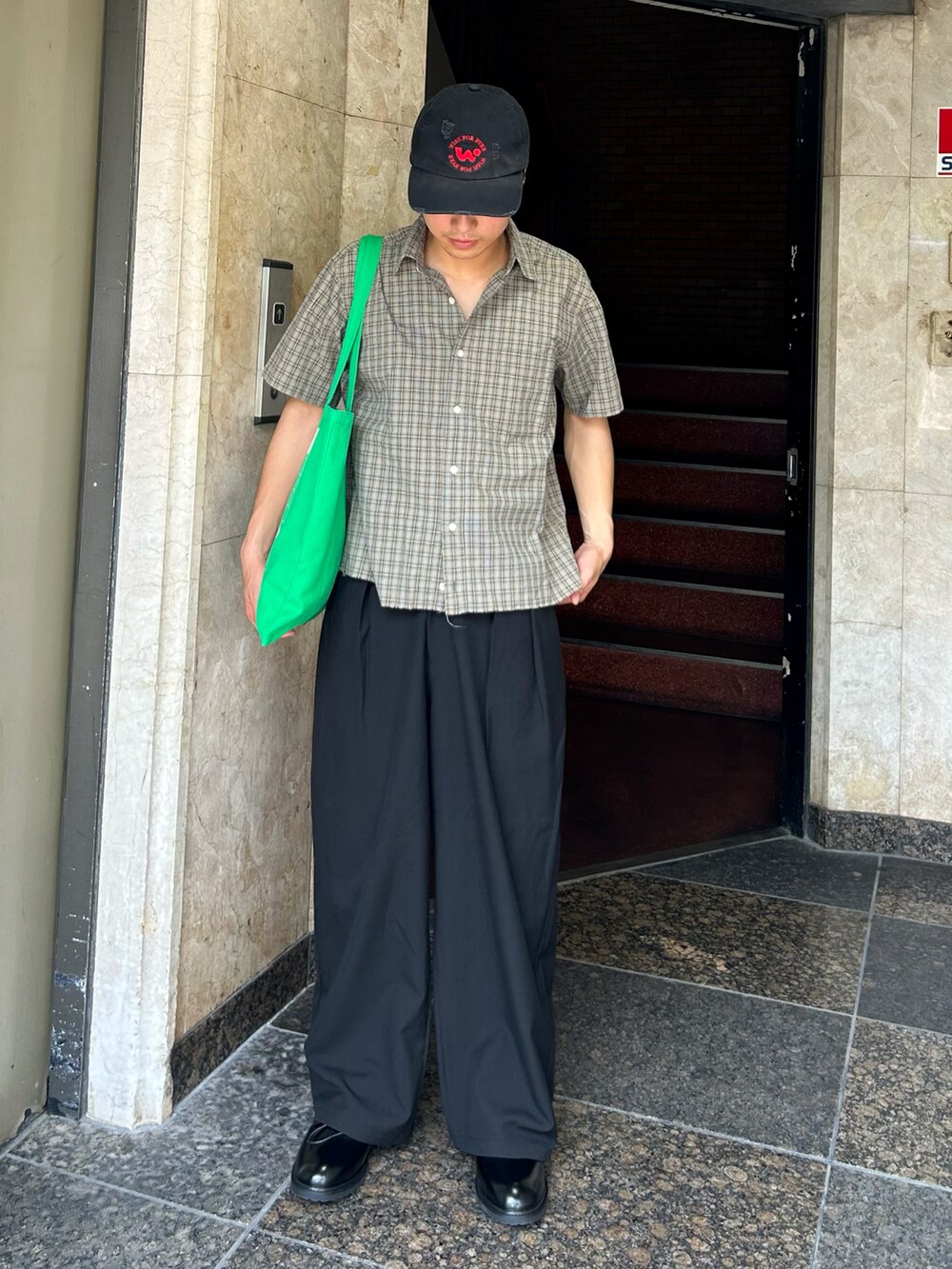 ブラック系のスラックス、ブラック系のドレスシューズ、ベージュ系のシャツ/ブラウスを着用したメンズの夏コーディネートの2枚目の写真