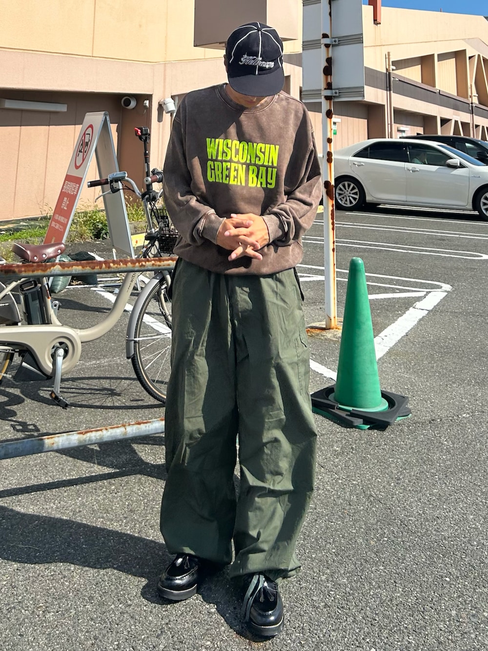 グリーン系のカーゴパンツ、ブラック系のローファー、ブラウン系のスウェットを着用したメンズの秋コーディネートの2枚目の写真