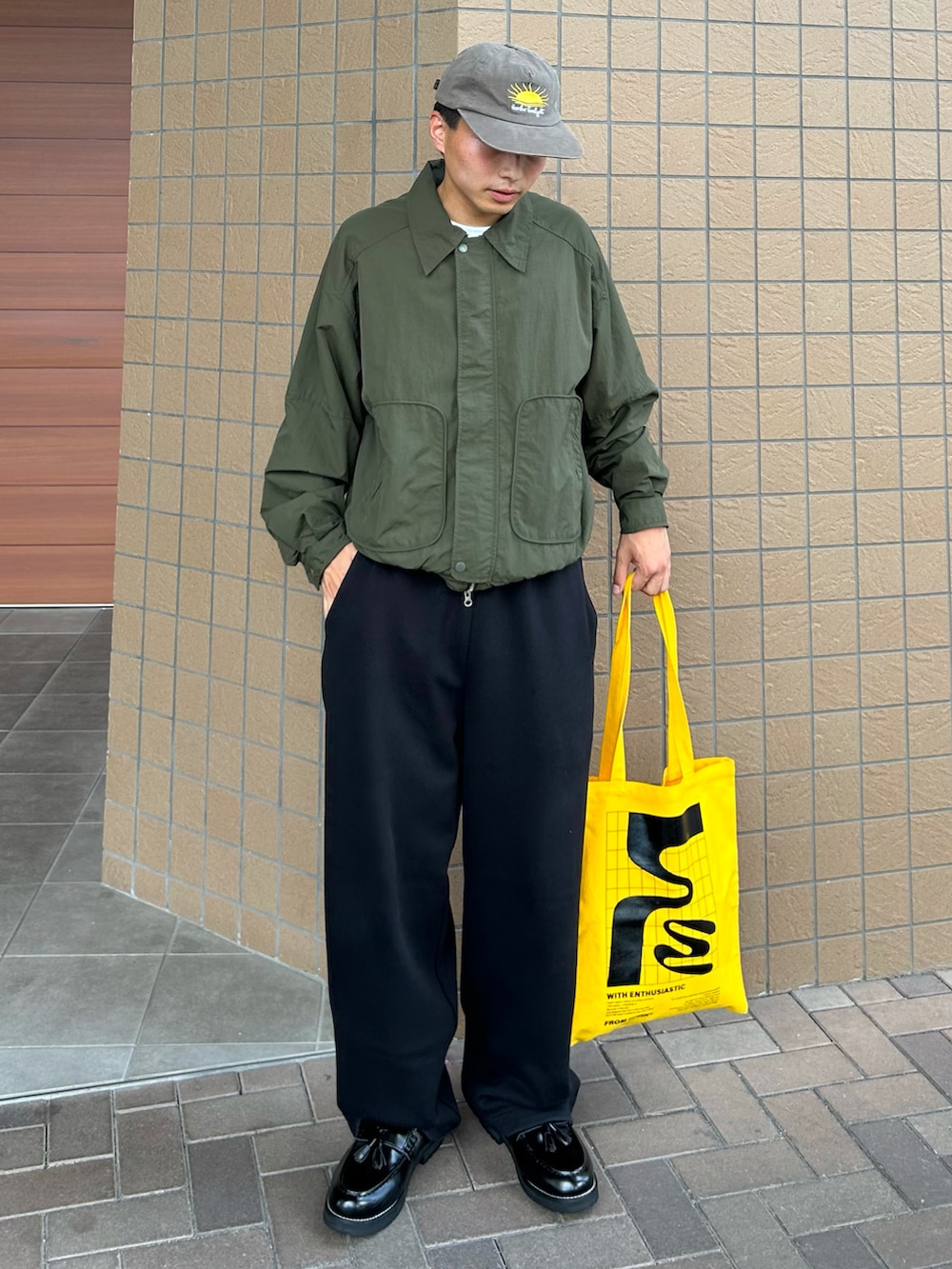 ブラック系のローファー、グリーン系のテーラードジャケット、ブルー系のスウェットパンツを着用したメンズの秋コーディネートの2枚目の写真