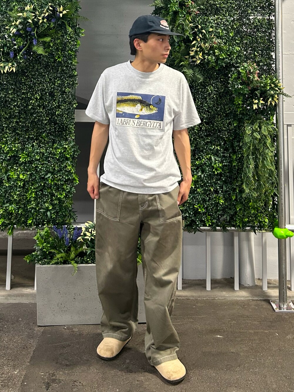 ベージュ系のサンダル、グレー系のTシャツ/カットソー、グリーン系のパンツを着用したメンズの夏コーディネートの2枚目の写真