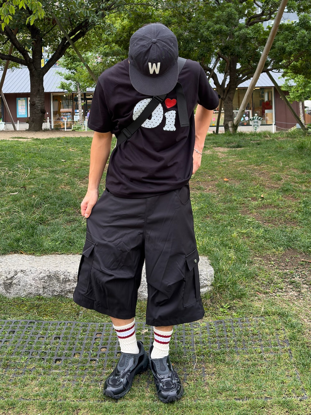 ブラック系のTシャツ/カットソー、ブラック系のスニーカー、ブラック系のパンツを着用したメンズの夏コーディネートの2枚目の写真