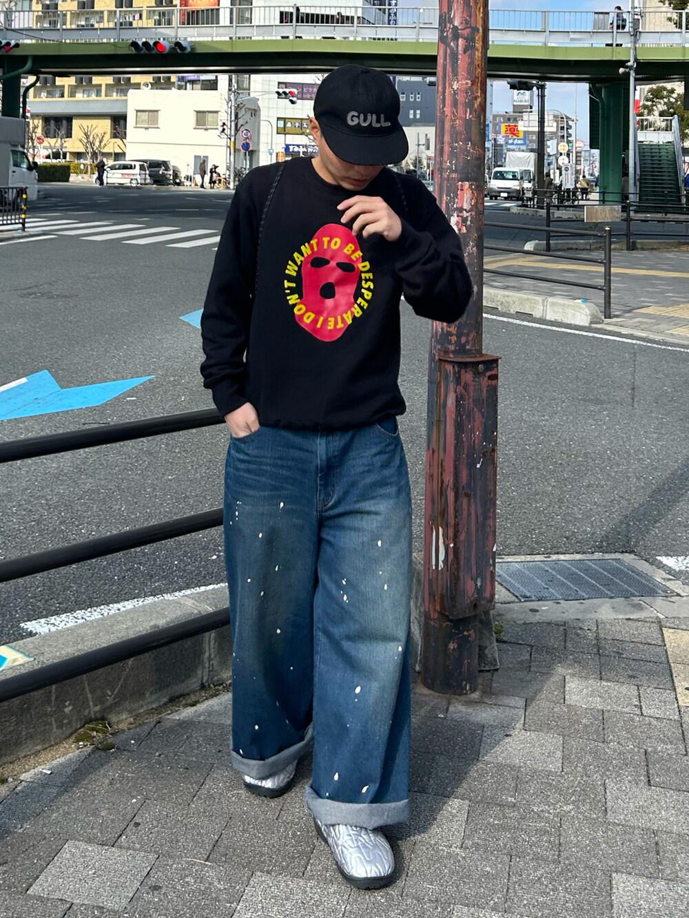 ブラック系のスウェット、ブルー系のデニムパンツ、シルバー系のサンダルを着用したメンズの冬コーディネートの2枚目の写真