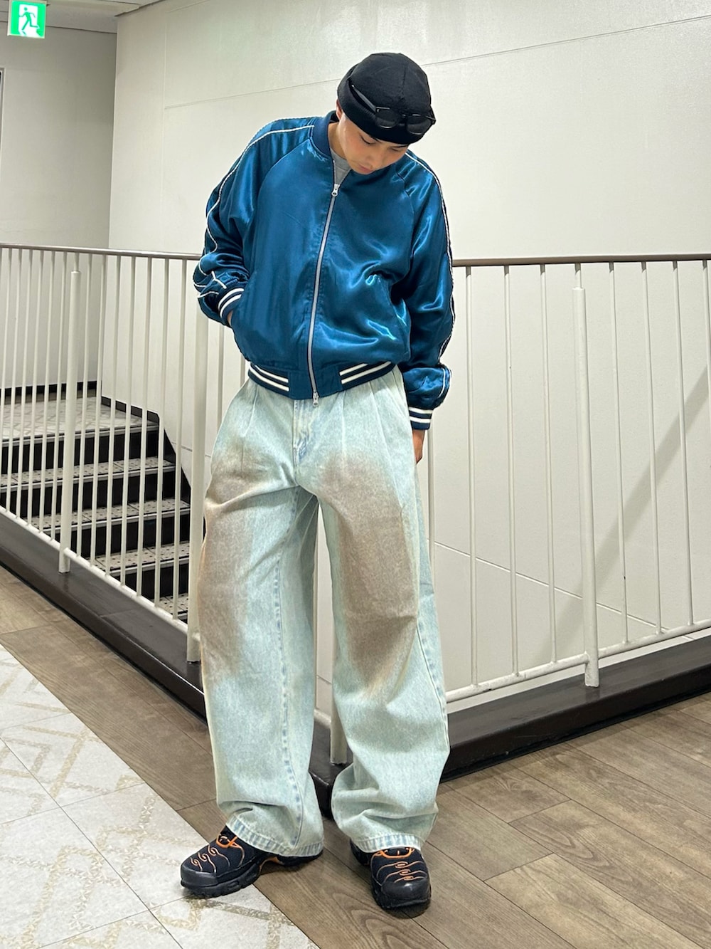 ブルー系のデニムパンツ、ブルー系のスカジャン、ブラック系のスニーカーを着用したメンズの冬コーディネートの2枚目の写真