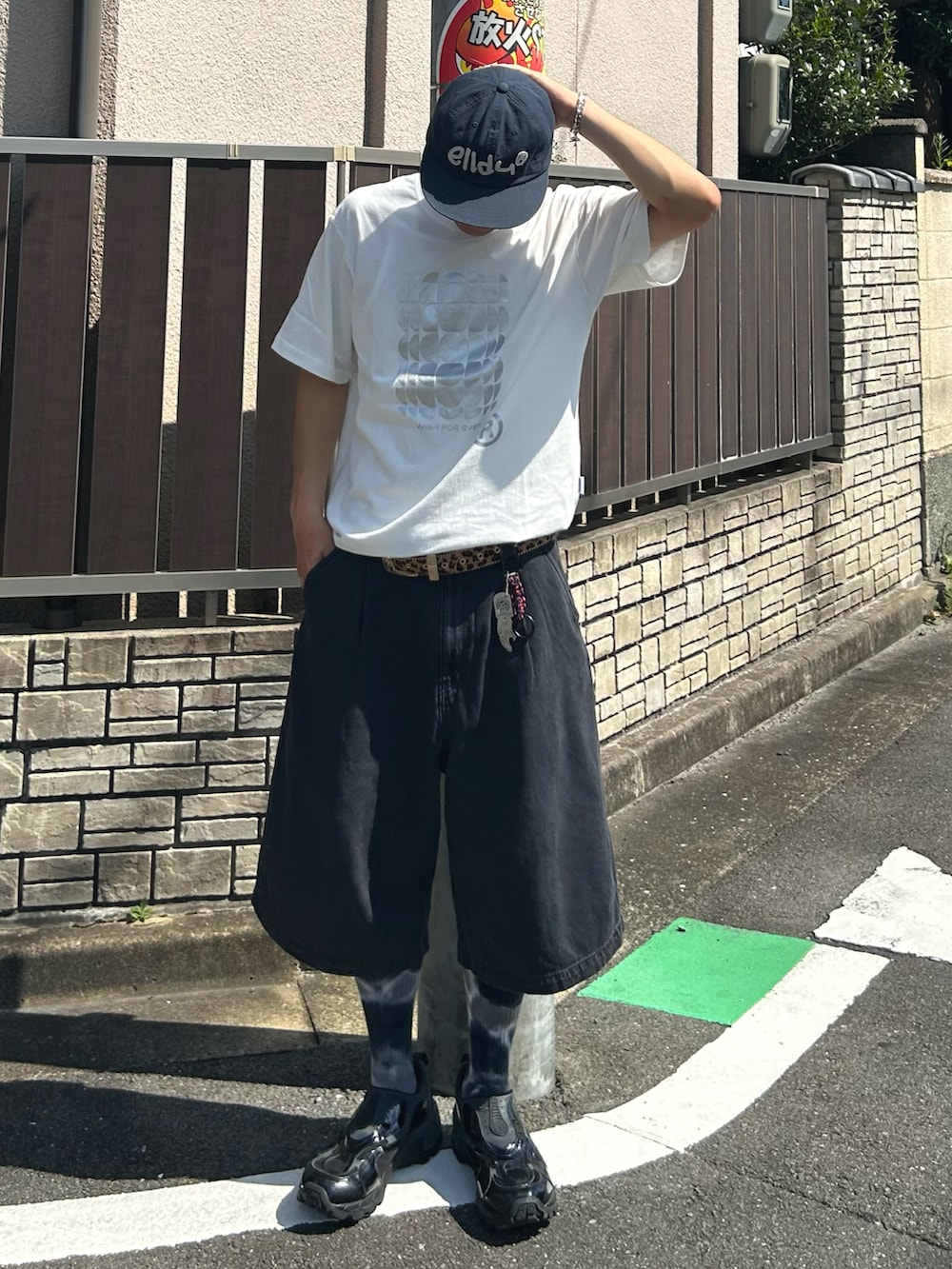 ブラック系のデニムパンツ、ホワイト系のTシャツ/カットソー、ブラック系のスニーカーを着用したメンズの夏コーディネートの2枚目の写真