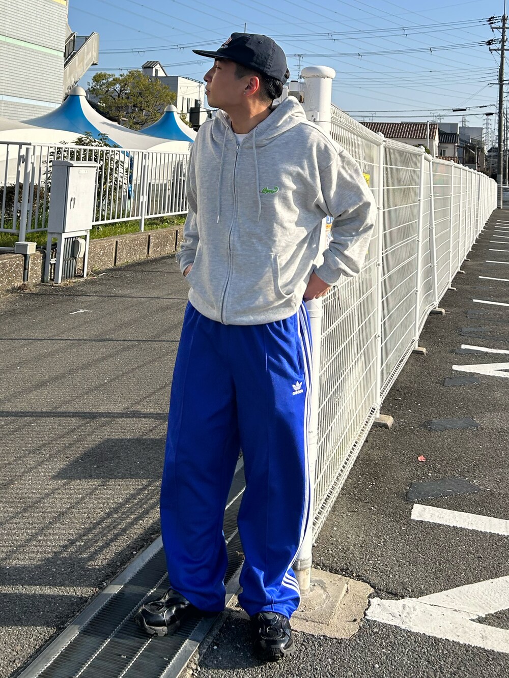 グレー系のパーカー、ブルー系のその他パンツ、ブラック系のスニーカーを着用したメンズの春コーディネートの2枚目の写真