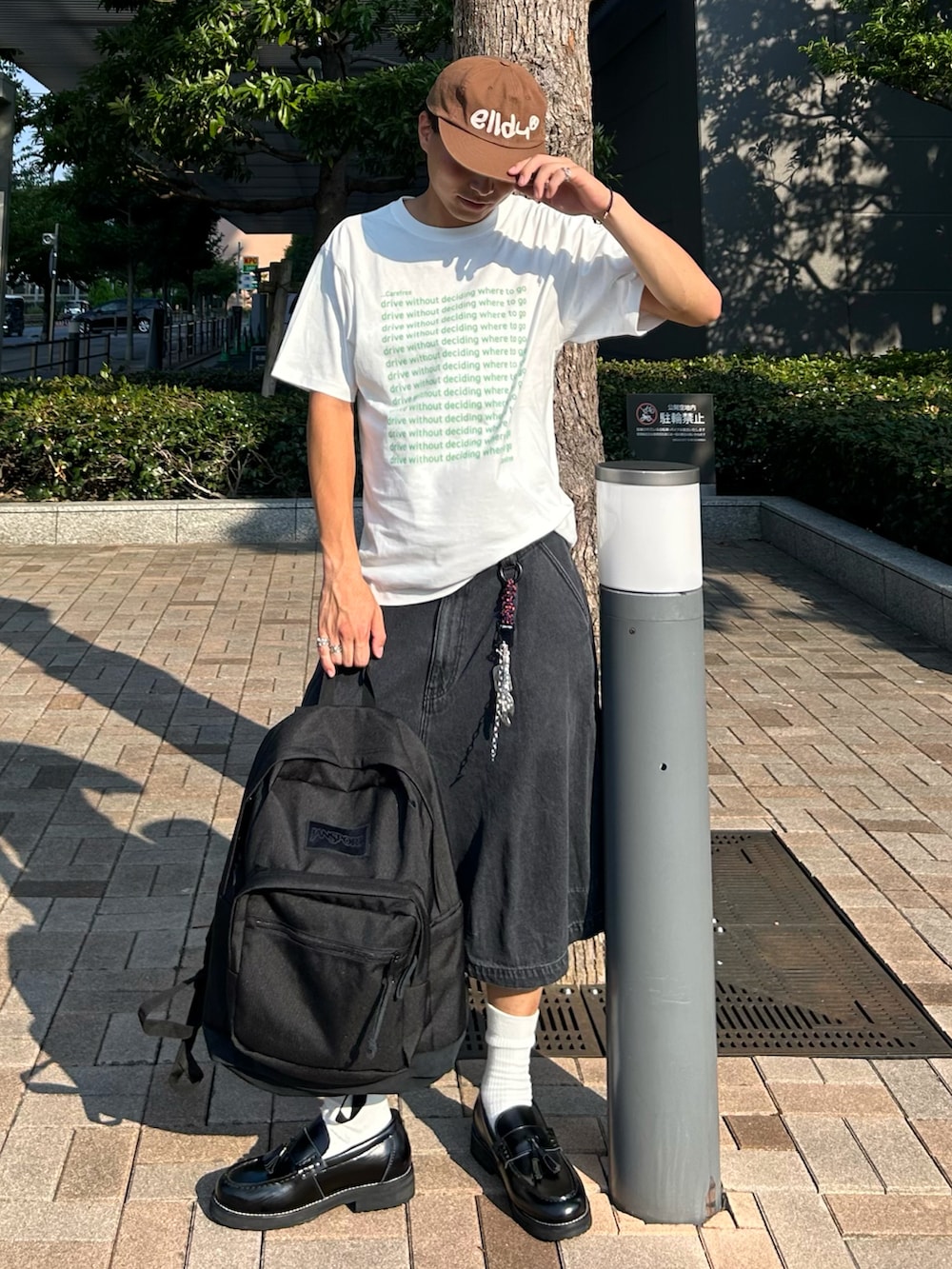 グリーン系のTシャツ/カットソー、ブラック系のデニムパンツ、ブラック系のバックパック/リュックを着用したメンズの秋コーディネートの2枚目の写真