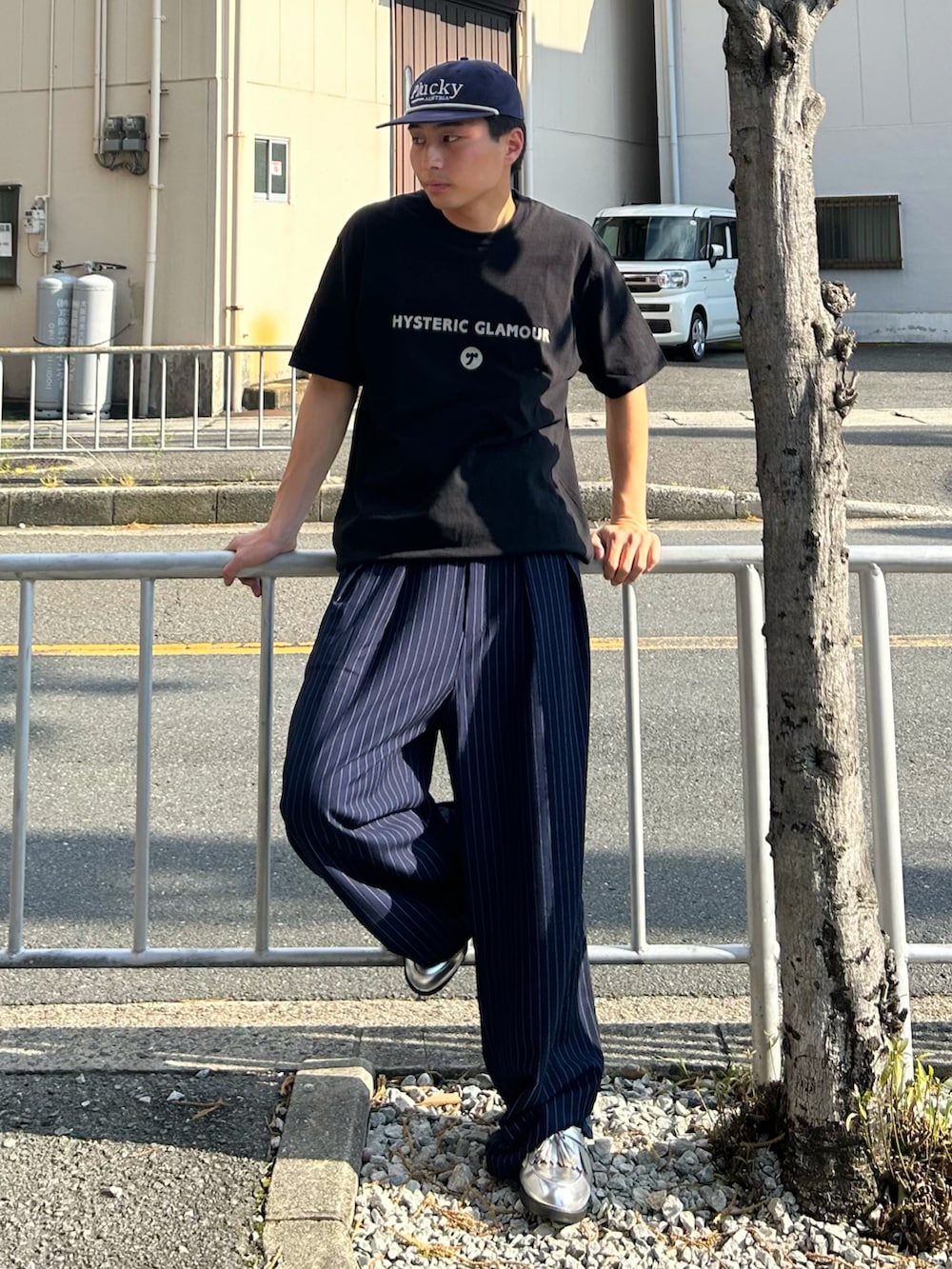 ブラック系のTシャツ/カットソー、ブルー系のスラックス、シルバー系のローファーを着用したメンズの夏コーディネートの2枚目の写真